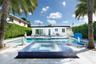 Exterior backyard space featuring an in-ground pool, a raised spa finished with blue glass mosaic tiles, light-toned stone patio surfacing, and privac