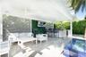 Covered outdoor patio featuring stone flooring, a built-in outdoor kitchen with stone countertops, a slatted privacy screen, integrated ceiling lighti