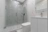 Walk-in glass-enclosed shower with a rainfall showerhead, large-format tile surround, mosaic tile flooring, and integrated wall niche, complemented by