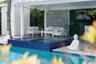 Covered outdoor lounge area featuring a blue mosaic tile spa, stone-finish decking, white slatted privacy screen, and recessed ceiling lighting