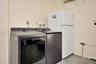 Laundry area featuring built-in shelving, plumbing connections for a washer and dryer, and a designated space for an upright refrigerator