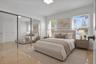 Bedroom featuring polished tile flooring, full-wall sliding mirrored closet doors, recessed ceiling lighting, and multiple windows with horizontal bli