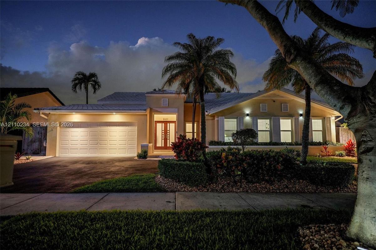 Single-story residence featuring a multi-paneled garage door, dual-entry front door with glass inserts, neutral exterior finish, pitched roofline, and