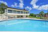 Swimming pool with tiled patio, integrated spa, second-level balcony, and exterior staircase