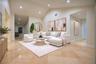 Expansive living area featuring vaulted ceilings, recessed lighting, and neutral stone-finish tile flooring