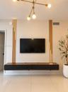 Wall-mounted floating media console featuring a two-tone wood and matte black finish, accented by vertical wood slat wall detailing with integrated li