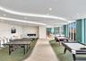 Expansive interior space featuring a curved dropped ceiling, recessed lighting, floor-to-ceiling windows, and dual-textured carpeting