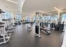 Fitness center featuring floor-to-ceiling windows, rubberized flooring, recessed linear lighting, and wall-to-wall mirrors