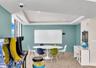 Tray ceiling with recessed lighting, wall-mounted whiteboard, and textured wall finish