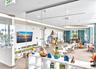 Floor-to-ceiling glass wall partitions, neutral carpeting, recessed lighting, and expansive windows