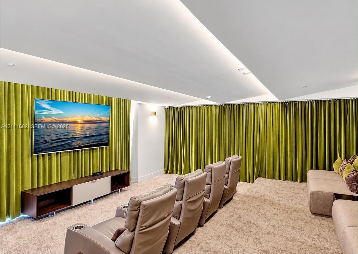 Tray ceiling featuring recessed perimeter lighting, wall-to-wall integrated textile drapery, and neutral carpeting