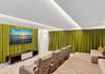 Tray ceiling featuring recessed perimeter lighting, wall-to-wall integrated textile drapery, and neutral carpeting