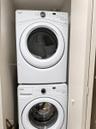 Stackable Whirlpool washer and dryer unit with front-loading glass doors and digital control panels