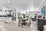 Open-concept interior featuring large-format tile flooring, recessed lighting, crown molding, and a glass-paneled exterior door