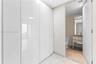 Floor-to-ceiling high-gloss white built-in cabinetry, large-format tile flooring, vanity with wood-finish cabinetry, rectangular vessel sink, and wall