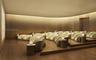 Curved room featuring wood-finish flooring, tiered platform seating, integrated cove lighting, and floor-to-ceiling metallic wall paneling