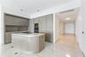Kitchen featuring high-gloss cabinetry, stone-surface center island with integrated cooktop, built-in double wall oven, and large-format tile flooring