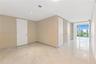 Polished stone flooring with veining, recessed lighting, smooth-finish ceilings, and floor-to-ceiling glass panel doors
