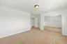 An inviting third bedroom offering a large mirrored closet, neutral finishes, and ample space for comfortable living.