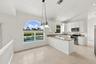 Enjoy picturesque views of the surrounding greenery from the charming breakfast nook, complete with an oversized arched window, vaulted ceilings, and 