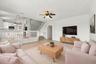 The generous formal living room offers soaring ceilings, an elegant chandelier, and an open design overlooking the home's grand entryway.