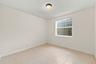 This well-appointed main-level bedroom offers flexibility for guests, a private office, or additional living space, with convenient access to the home