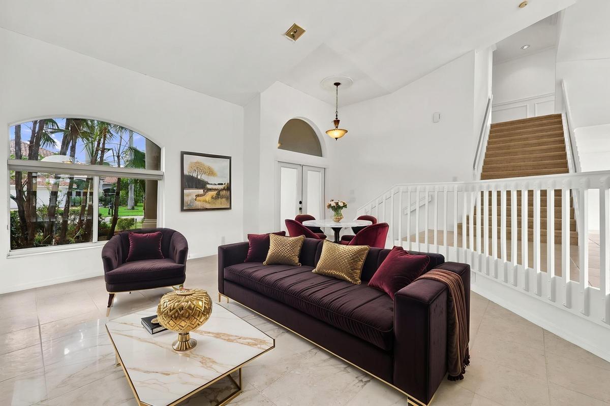 Impressive formal living room with dramatic vaulted ceilings, oversized arched windows, and an open, airy design that creates a wonderful first impres