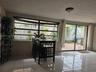 Large horizontal window with black frames, tile flooring, and sliding glass door