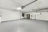 This oversized three-car garage features a finished floor, utility sink, and ample room for vehicles, recreational equipment, additional storage, or a