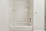A convenient tub and shower combination with neutral tile surrounds provides comfort and functionality in this second-floor bathroom, ideally situated