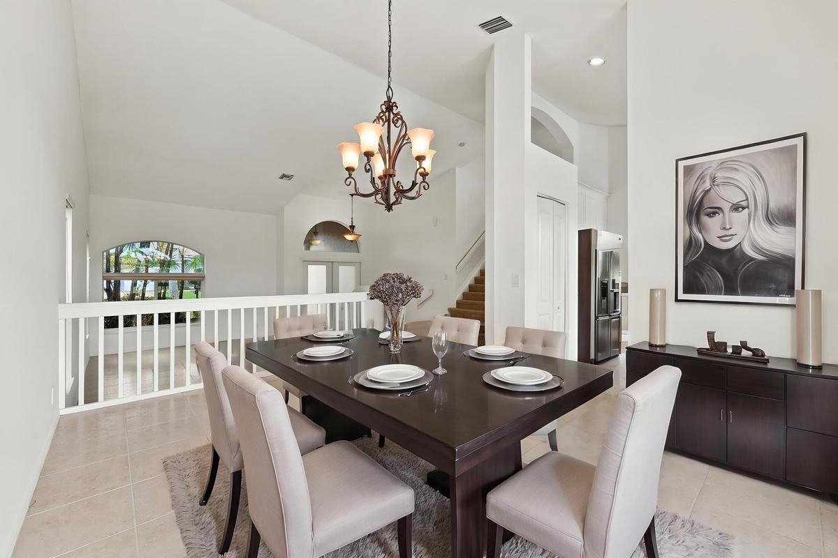 The formal dining room features impressive ceiling heights, decorative lighting, and an open design that adds to the home's spacious character
