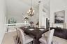 The formal dining room features impressive ceiling heights, decorative lighting, and an open design that adds to the home's spacious character