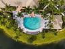 An overhead perspective showcasing the Boca Isles South clubhouse, resort-style swimming pool, and surrounding recreational amenities.