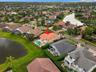 A bird's-eye view showcasing the property's position among neighboring residences, tropical landscaping, and scenic waterways.