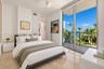 Floor-to-ceiling sliding glass doors, private balcony, polished stone flooring, recessed ceiling fan, and crisp white wall finishes