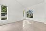 Soaring vaulted ceilings, expansive windows, and abundant natural light create a bright, inviting formal living room with an impressive sense of space
