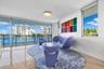 Floor-to-ceiling windows, polished stone flooring, recessed ceiling lighting, and a metal-framed balcony railing