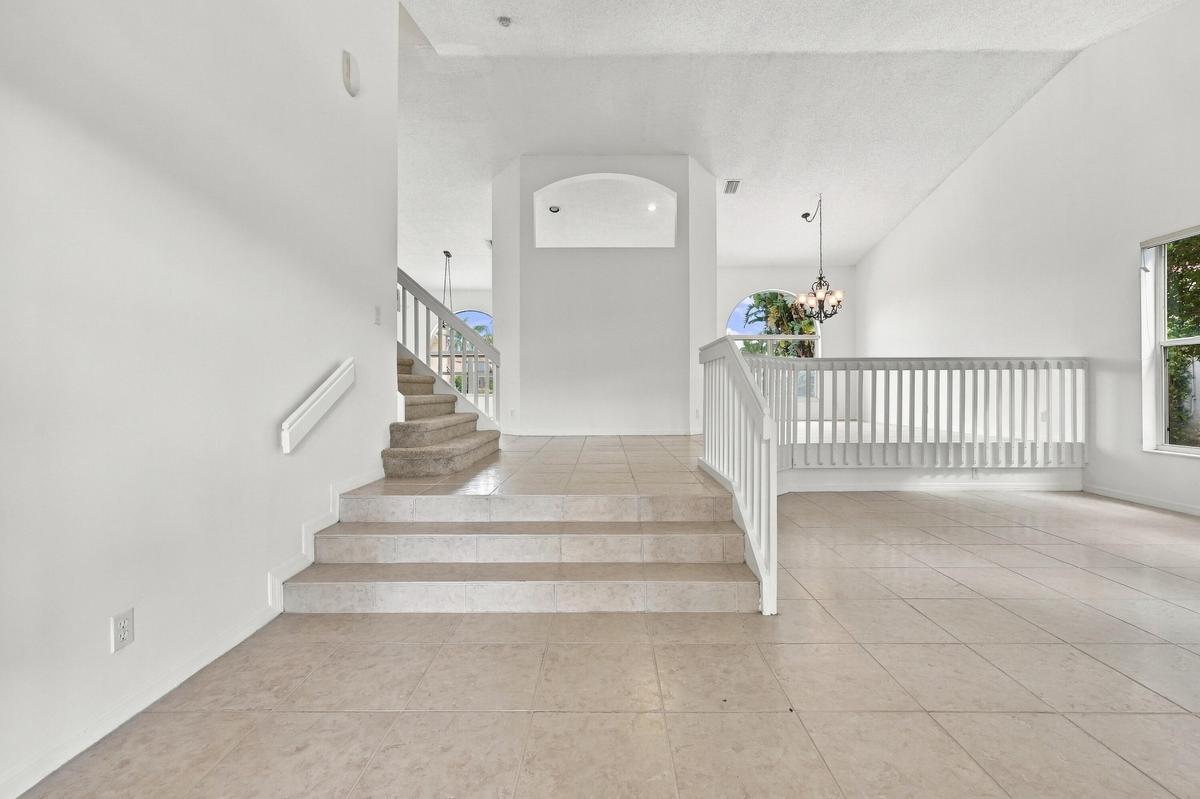 An elegant staircase with white railings complements the home's spacious, multi-level design, creating an inviting transition between living spaces.