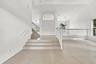 An elegant staircase with white railings complements the home's spacious, multi-level design, creating an inviting transition between living spaces.