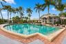 Experience resort-style living at the beautiful community swimming pool, surrounded by swaying palms, expansive lounging areas, and the impressive Boc