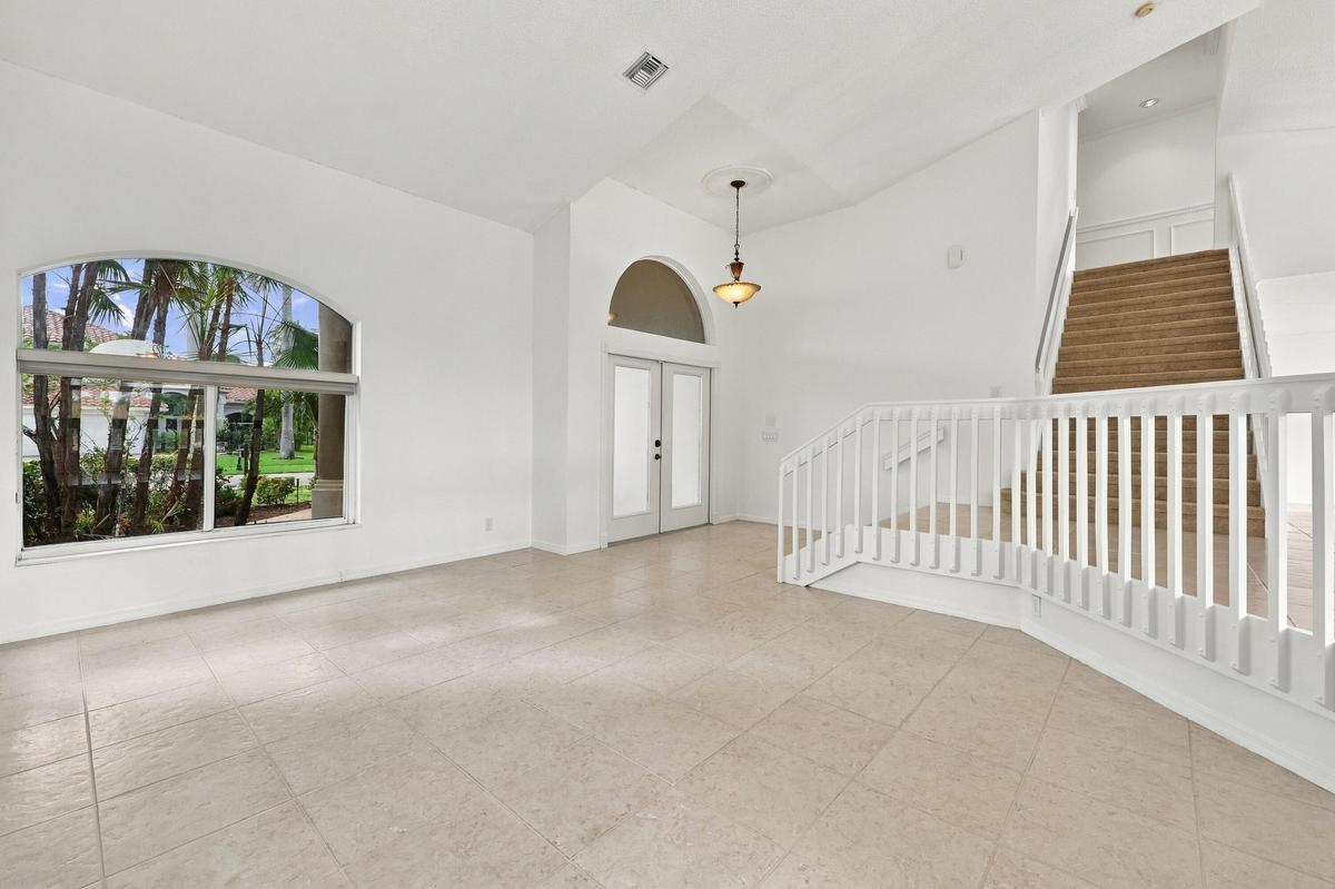 Impressive formal living room with dramatic vaulted ceilings, oversized arched windows, and an open, airy design that creates a wonderful first impres