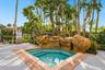 Unwind in the community spa, surrounded by natural rock features and tropical landscaping, offering a relaxing retreat just moments from home.
