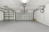 An impressive three-car garage featuring a finished floor, multiple overhead doors, and exceptional room for vehicles, recreational equipment, and add