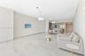 Large-format neutral flooring with veining, dual modern drum pendant lighting, and built-in kitchen cabinetry