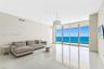 Polished stone flooring, floor-to-ceiling glass sliding doors, private balcony, and pendant lighting