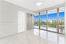 Interior space featuring large-format stone-look porcelain tile flooring, floor-to-ceiling glass sliding doors, built-in high-gloss cabinetry, and a c