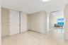 Large-format polished tile flooring with natural stone-style veining, high ceilings with recessed lighting, and expansive floor-to-ceiling windows fea
