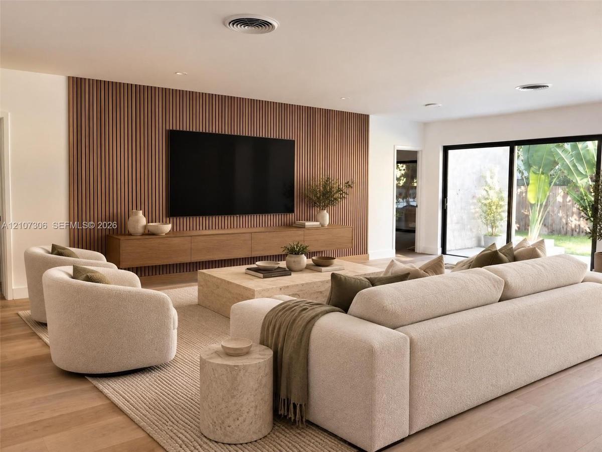 Vertical slat wood feature wall with a built-in wall-mounted media console, wood-finish flooring, and expansive sliding glass doors