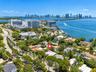Aerial perspective featuring mature coastal landscaping, proximity to the bay, and a cityscape backdrop