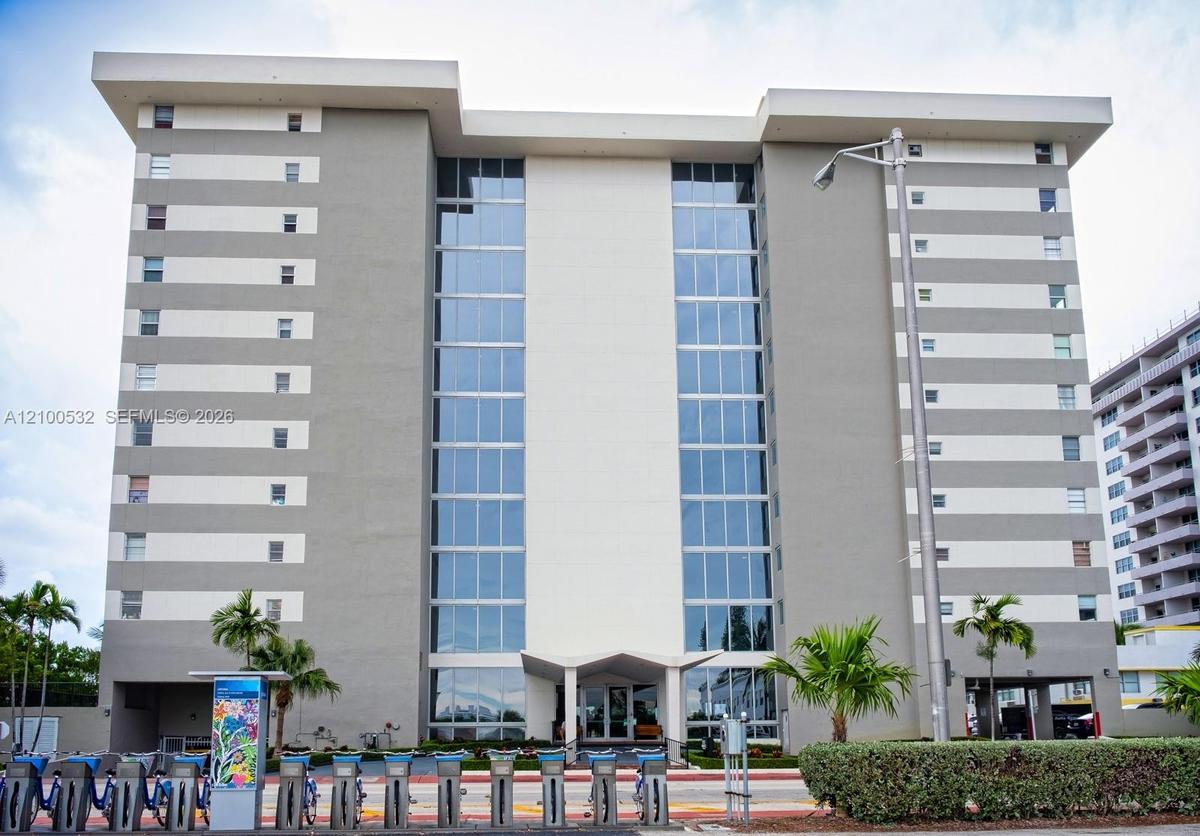 Multi-story mid-century modern architectural design featuring a central glass curtain wall, flat roofline, and contrasting horizontal facade panels